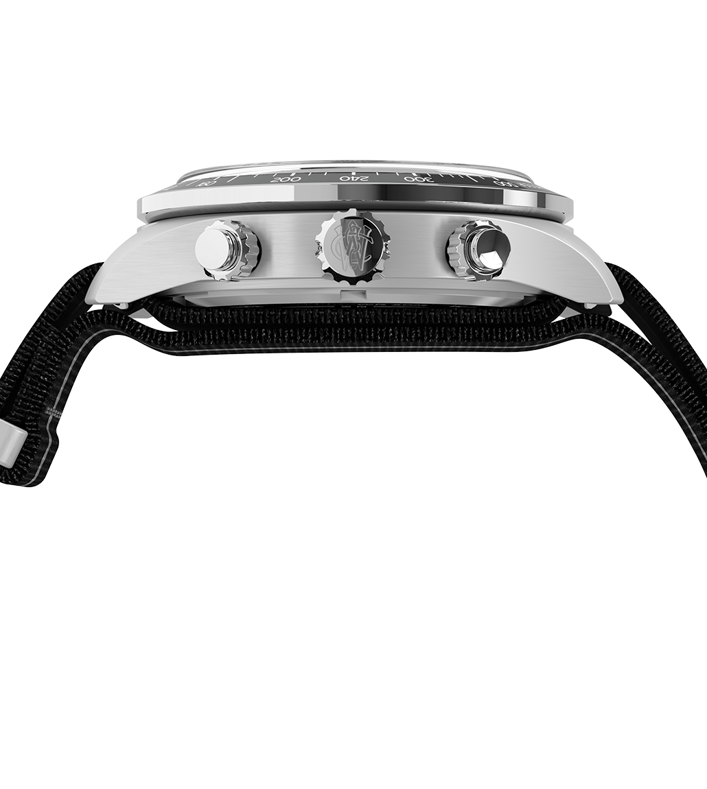 Front product image of the Timex Waterbury Heritage Chronograph featuring a brushed silver-tone dial with black sub-dials, black tachymeter bezel, silver-tone hands and markers, and a black strap with a white central stripe and silver hardware.