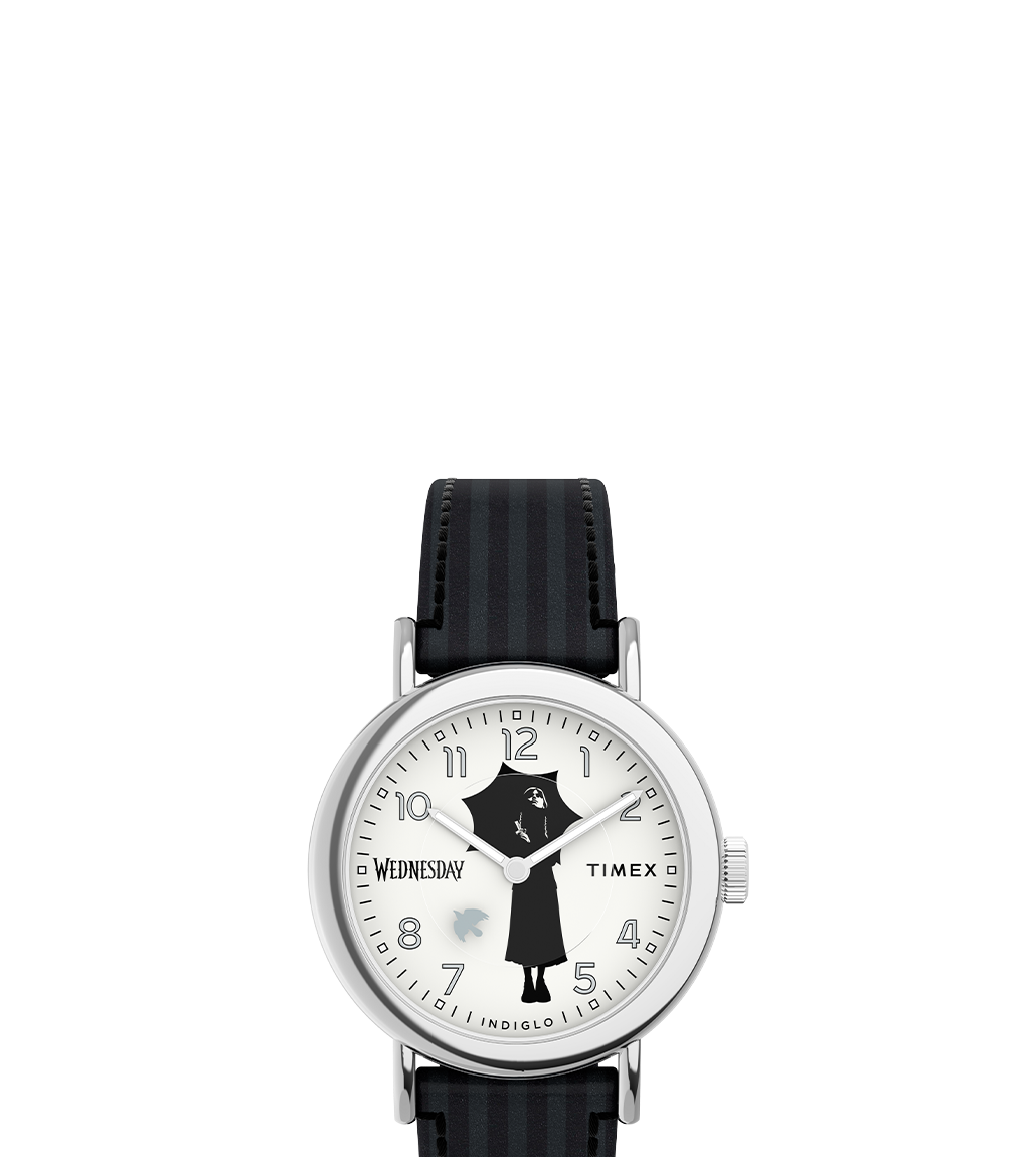 Close-up of the Timex x Wednesday analog watch with a black-and-white striped strap. The dial features a silhouette of Wednesday Addams holding an umbrella, with subtle gothic details.