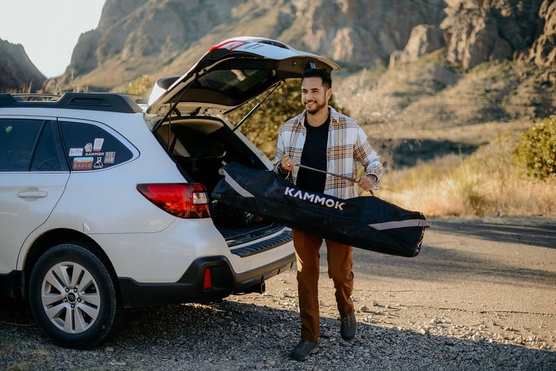 Man carrying Swiftlet portable hammock stand in travel bag.