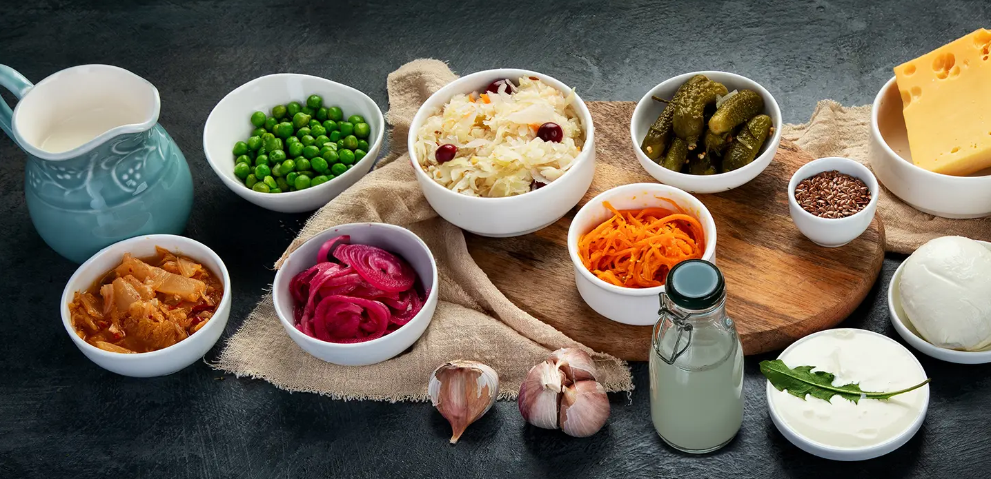 Assortment of fermented foods, including sauerkraut, kimchi, pickles, and yogurt, which are potential sources of probiotics.