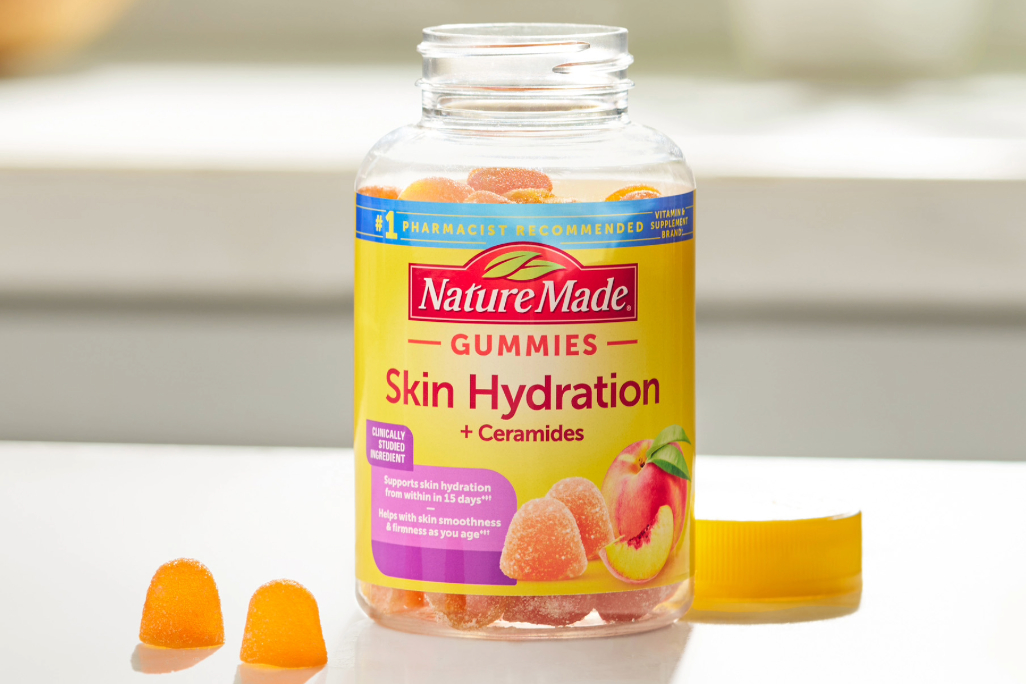 Nature Made Skin Hydration gummies bottle with gummies on a table
