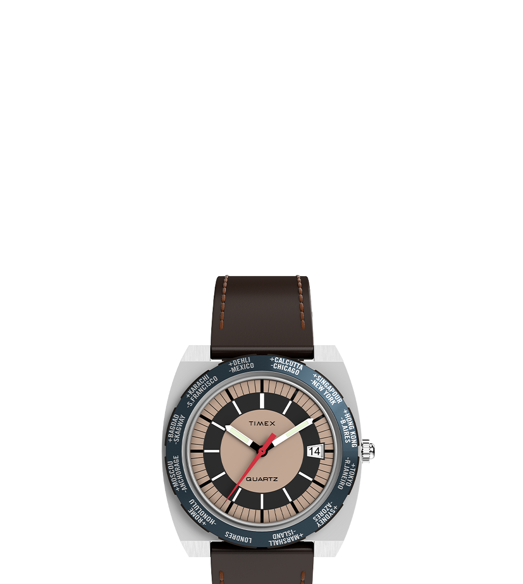 Front-facing view of the Q Timex® 1972 World Time watch against a white background. The timepiece features a brown leather strap with visible stitching, a world time bezel displaying major global cities, and a three-tone dial with prominent hour markers and a date window at 3 o'clock.