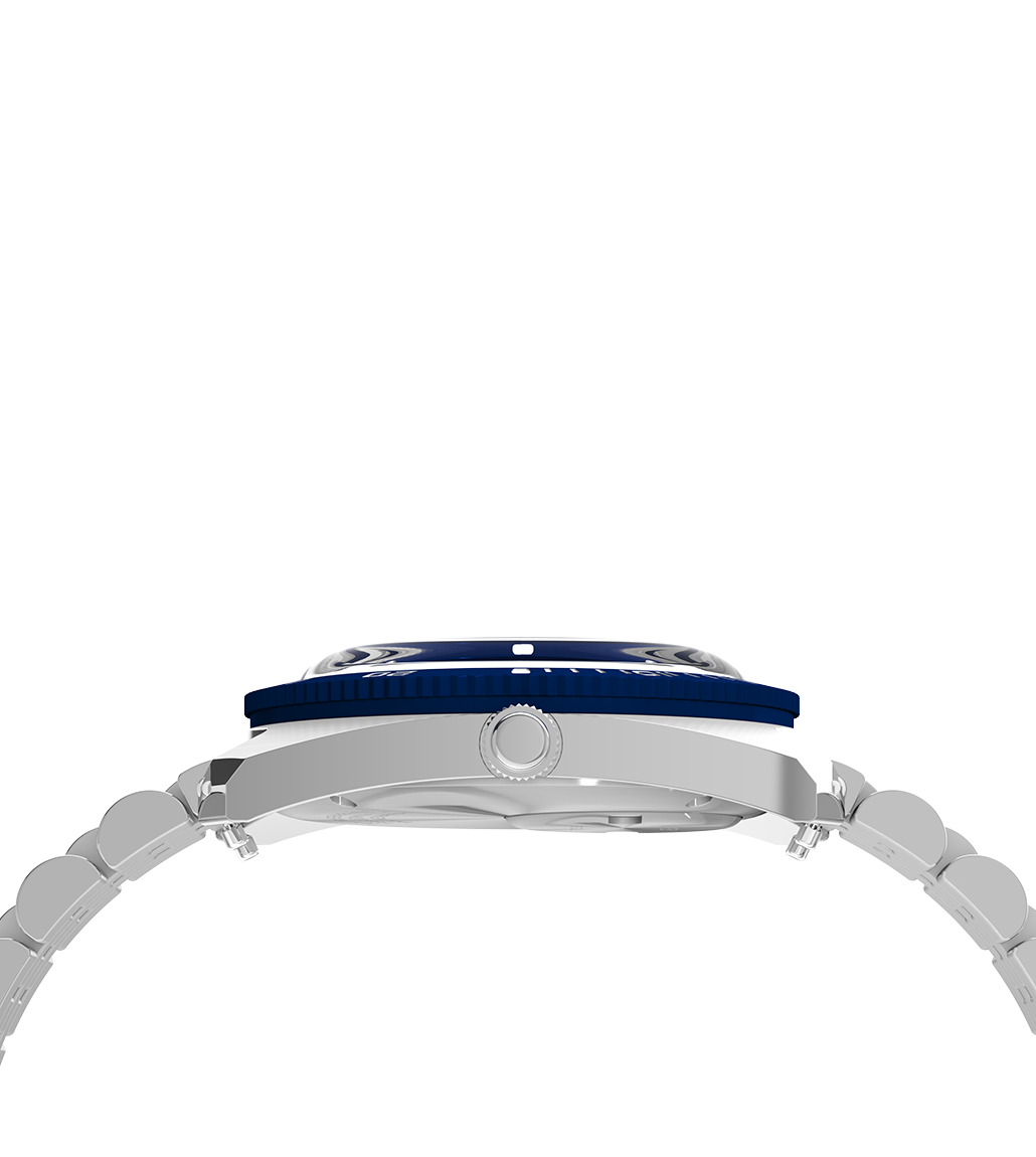 Side profile of the Q Timex® 1971 Velocity showing the domed crystal, notched rotating bezel, and textured crown. The view emphasizes the watch's slim case and curved bracelet integration.