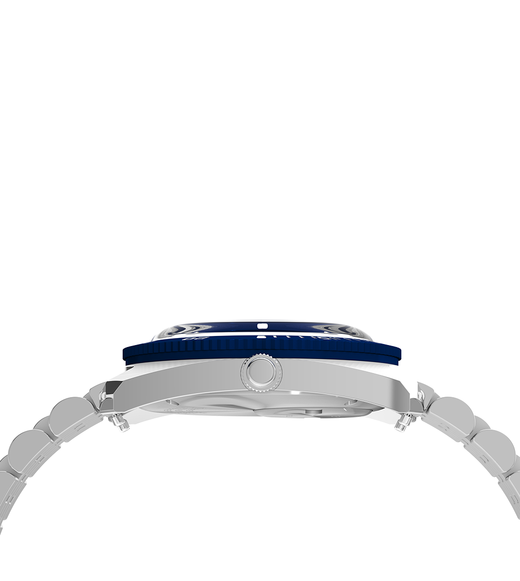 Side profile of the Q Timex® 1971 Velocity showing the domed crystal, notched rotating bezel, and textured crown. The view emphasizes the watch's slim case and curved bracelet integration.