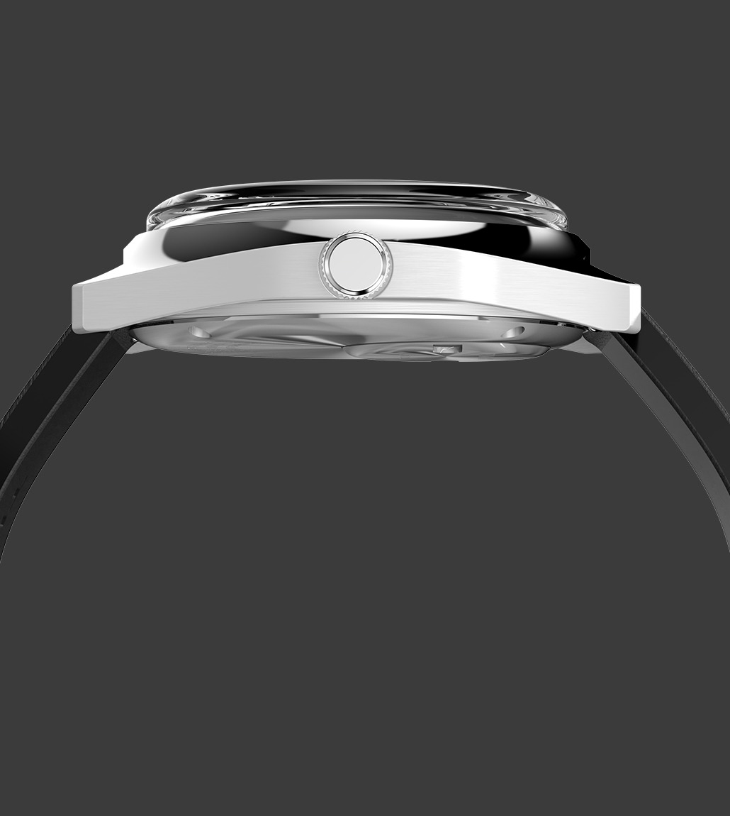 Side profile of the Q Timex® 1975 Enigma watch showing the polished stainless steel case, domed crystal, and crown placement. The slim case design and curvature of the strap are also visible.