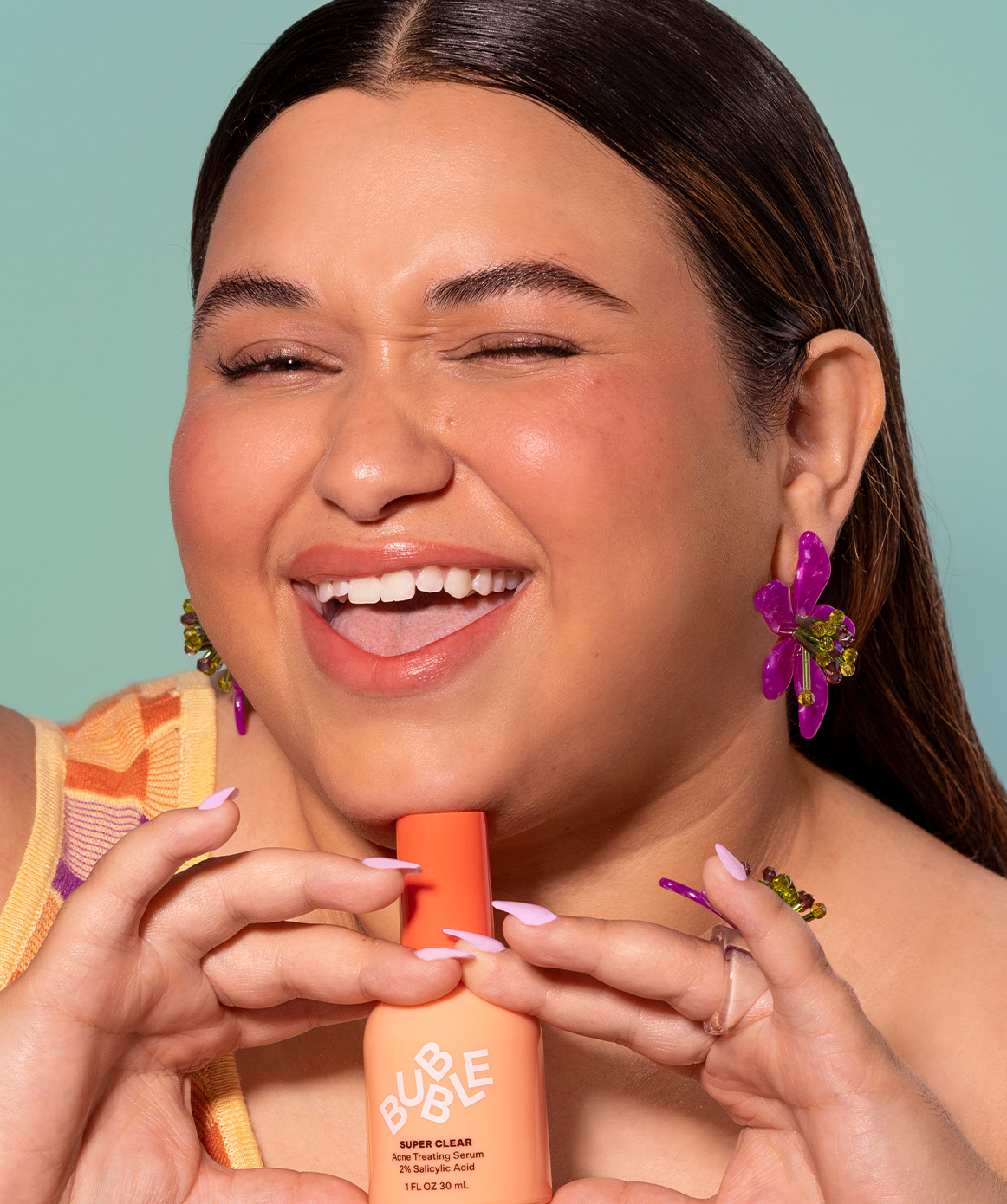 Plus size hispanic woman holding an anti-acne serum. Skin care treatment for blemishes, whiteheads, cystic zits, pimples and breakouts.