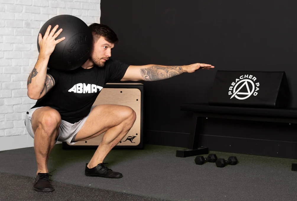 man doing medball squats