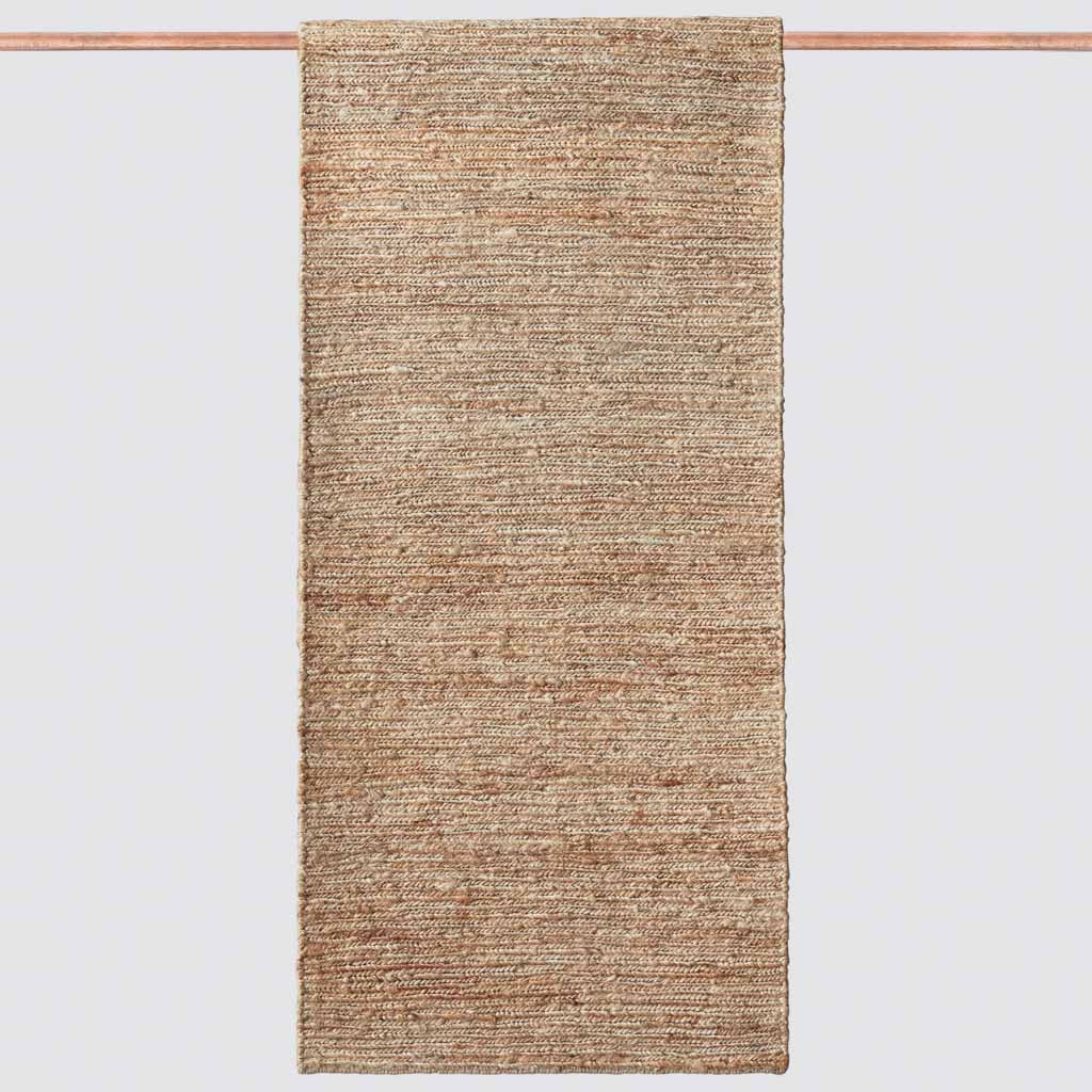 Jute rug styled on hardwood floor in modern hallway, dark