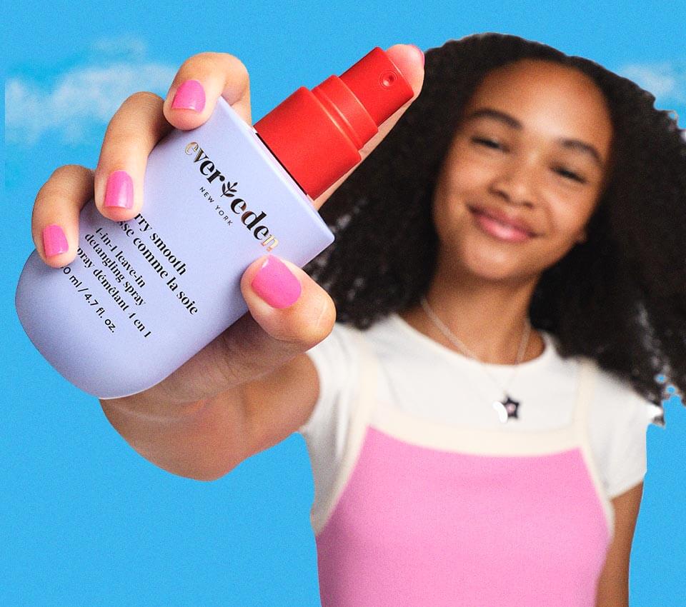 Girl holding Evereden skincare bottle.