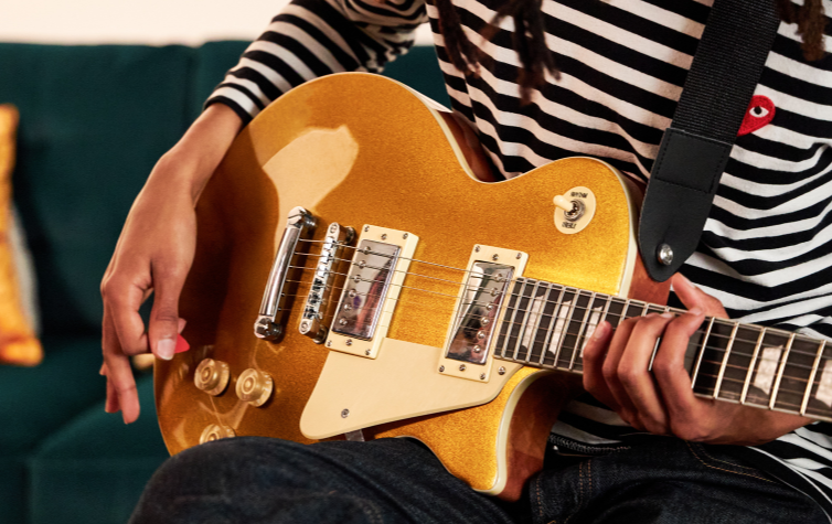 a person playing a honey beginner electric guitar 