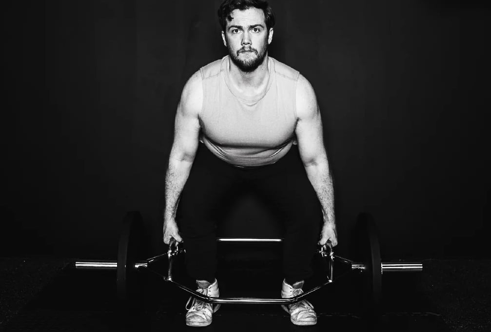 man doing deadlift with hex trap barbell