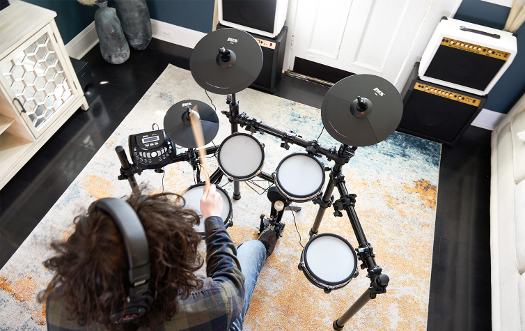 a person playing the 7 piece electronic drum set
