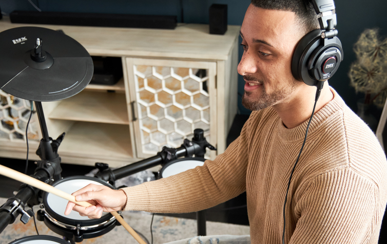 a person playing the 7 piece electronic drum set