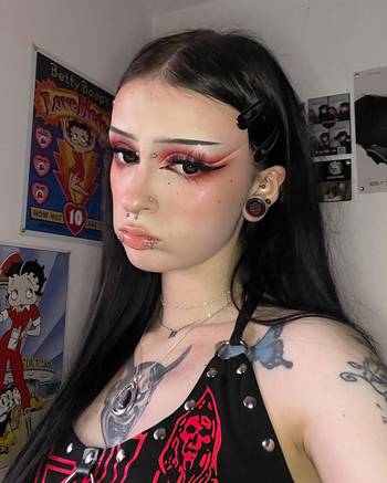 Woman wearing awesome demon face acrylic inlay and wood plugs / gauges