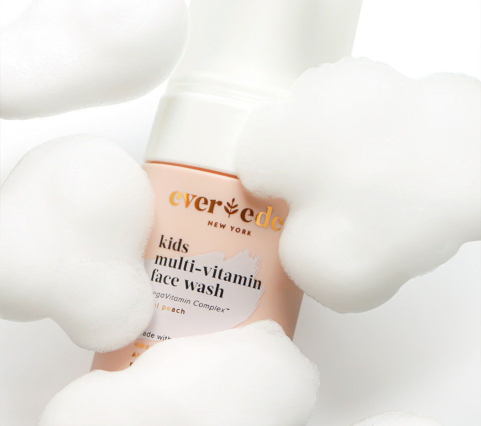 Evereden kids multi-vitamin face wash surrounded by fluffy foam.