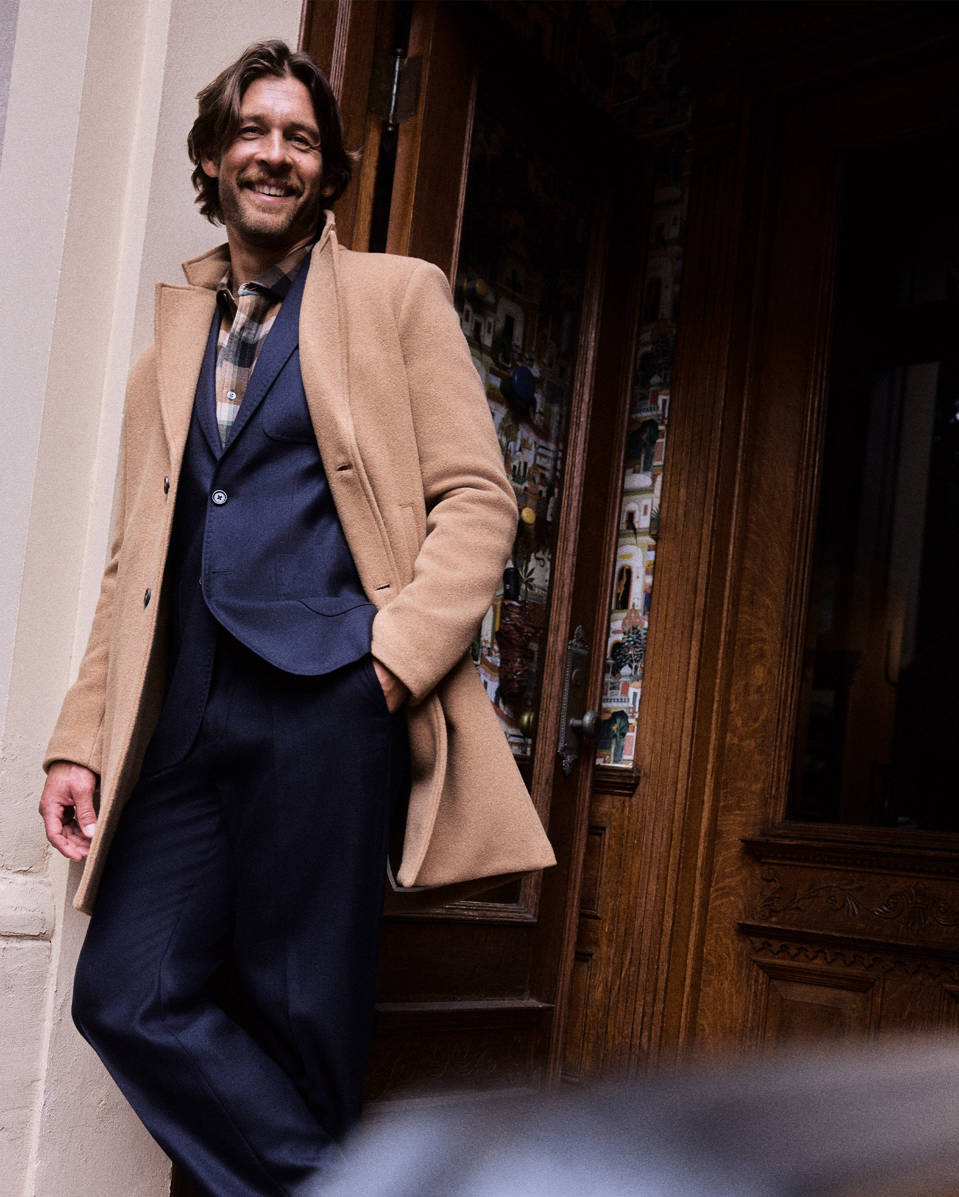 Model wears the Recycled Wool Coat over a suit.