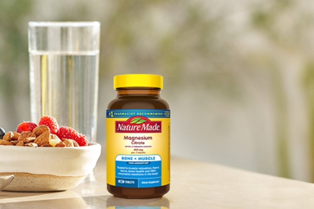 Nature Made Extra Strength Magnesium Citrate next to a glass of water.