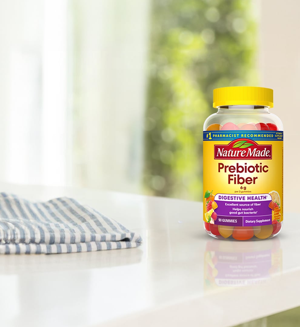 Nature Made Prebiotic Fiber gummies on a white counter next to a hand towel.