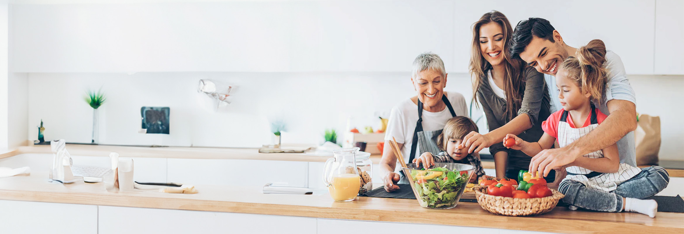 Family preparing fresh vegetables together in a modern kitchen for a healthy meal.