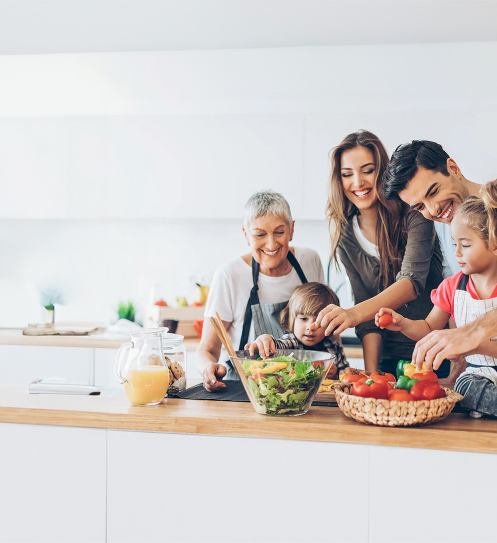 Family preparing fresh vegetables together in a modern kitchen for a healthy meal.