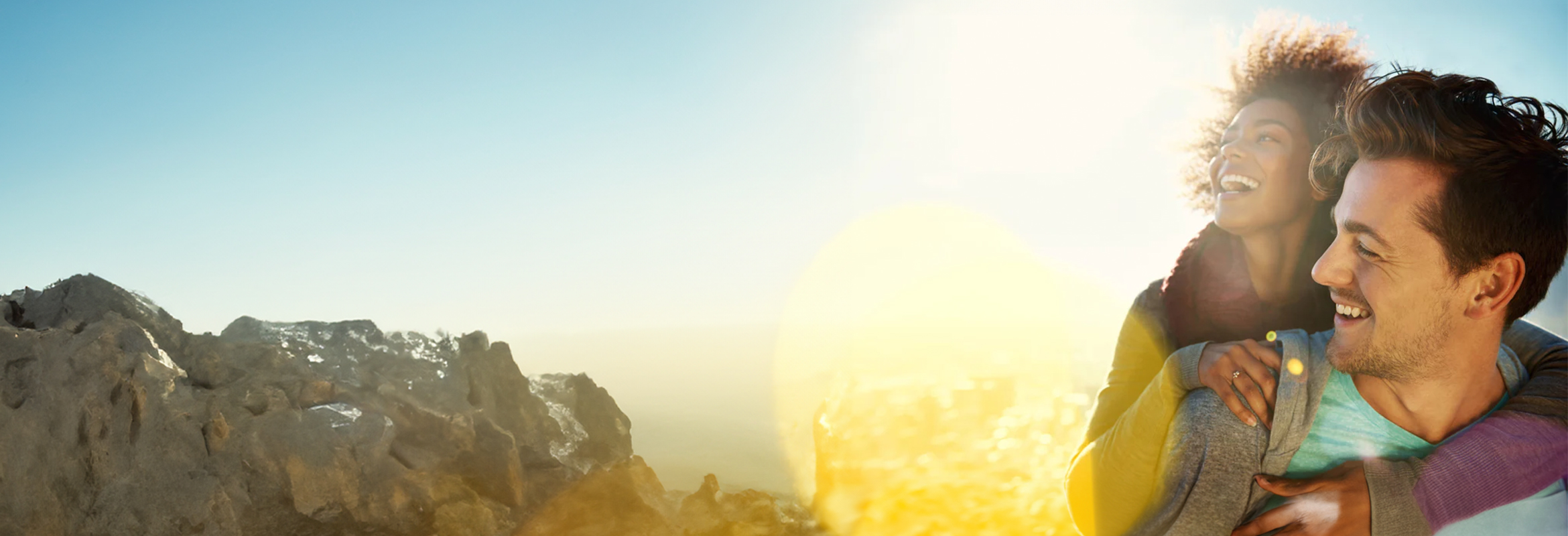 Two people smiling outdoor on a sunny day.