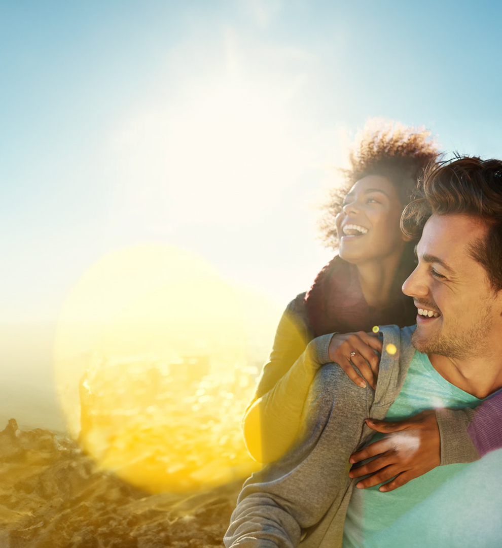 Two people smiling outdoor on a sunny day.