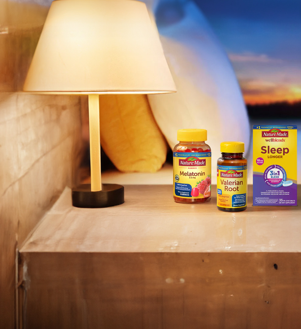 Nature Made supplements including Melatonin and Valerian Root on a bedside nightstand.