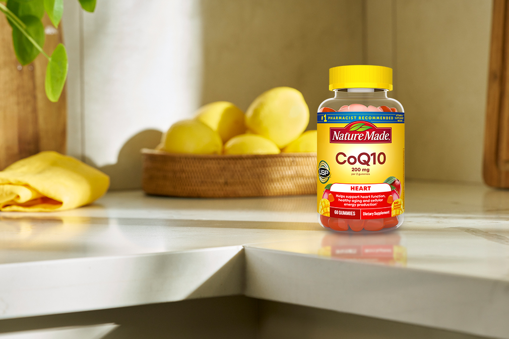 Nature Made CoQ10 gummies bottles on a modern kitchen counter.