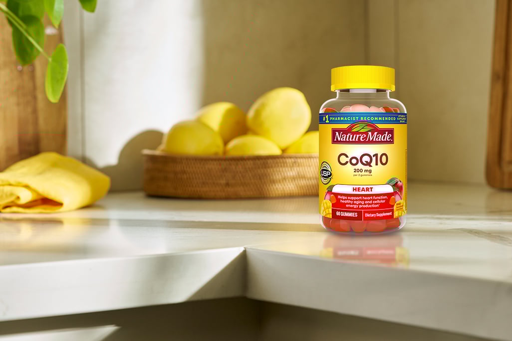 Nature Made CoQ10 gummies bottles on a modern kitchen counter.