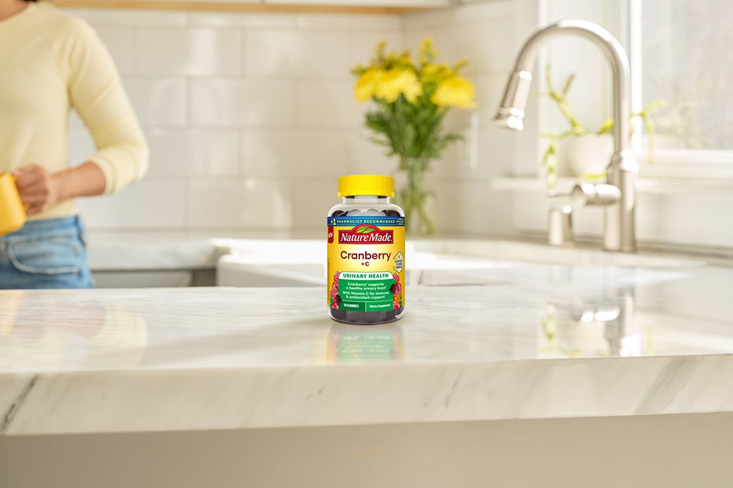 Cranberry with C Gummies on a kitchen counter with yellow flowers in the background.