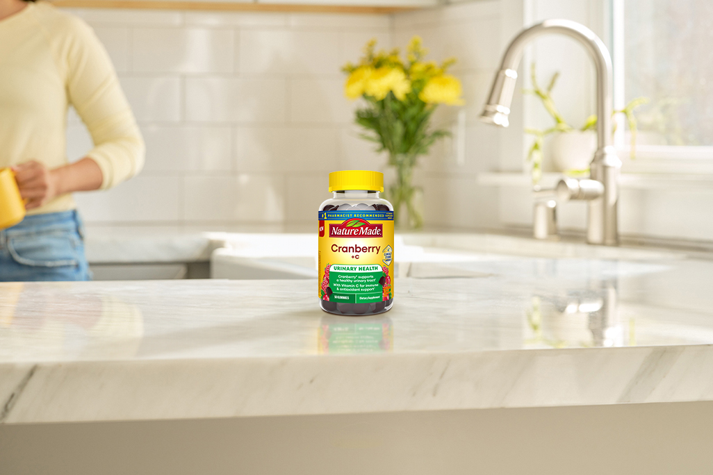 Cranberry with C Gummies on a kitchen counter with yellow flowers in the background.