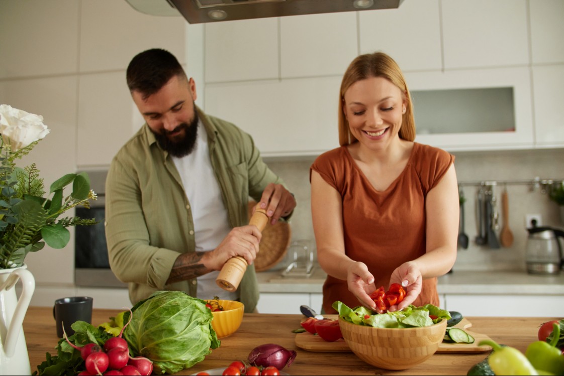 Adults in the kitchen preparing a healthy meal.