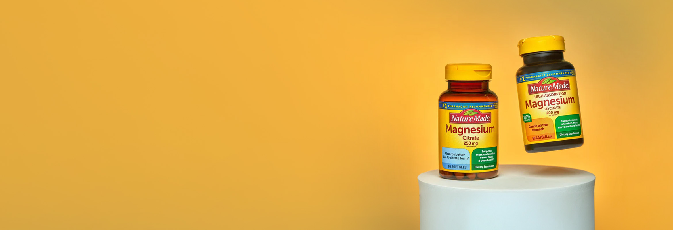 Nature Made magnesium supplements displayed on a pedestal against a yellow background.