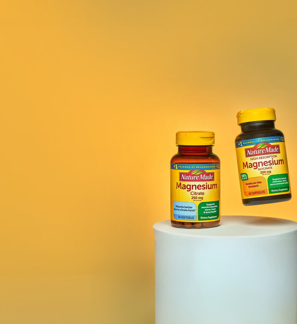 Nature Made magnesium supplements displayed on a pedestal against a yellow background.