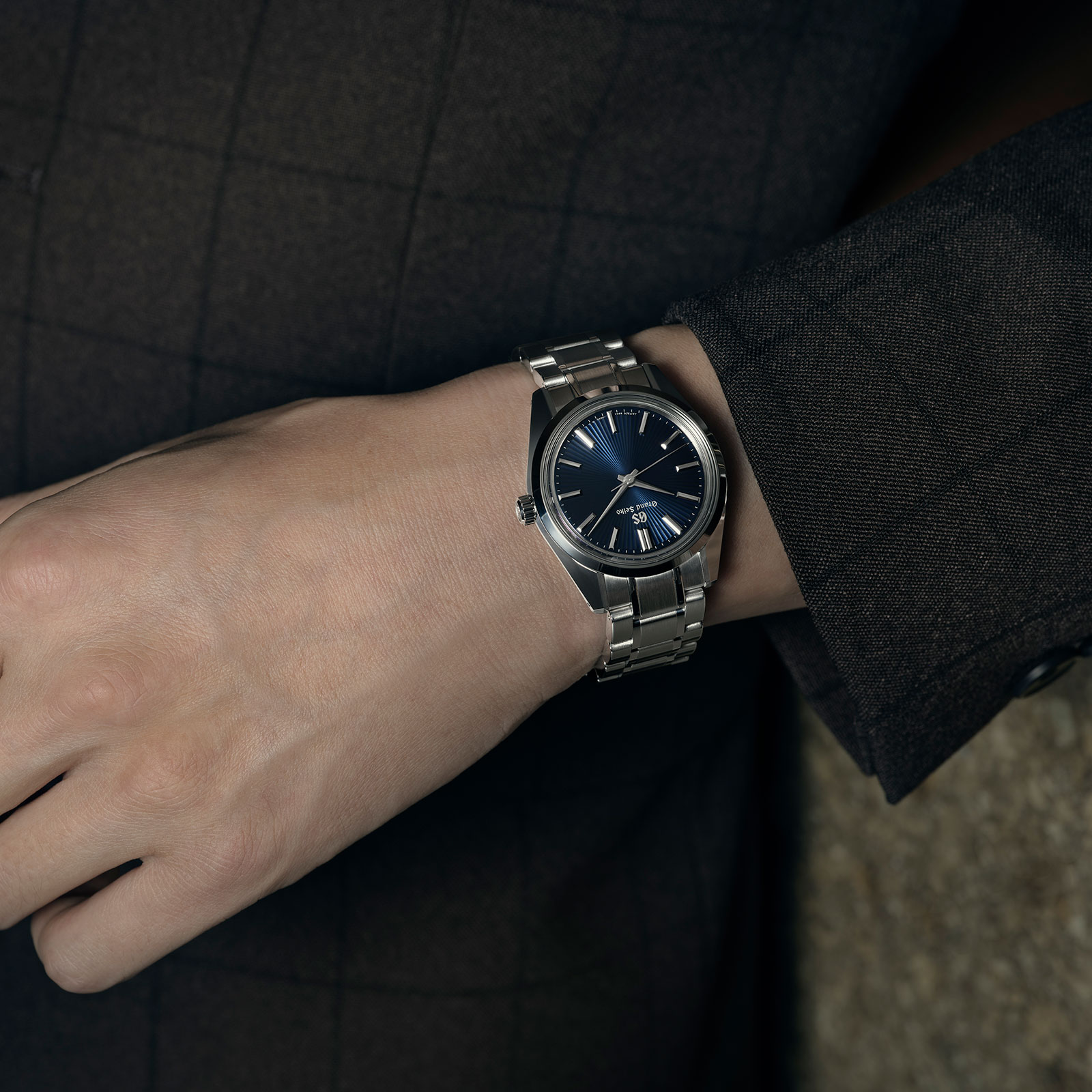 Grand Seiko SBGW299 blue dial sun ray pattern watch on wrist. 
