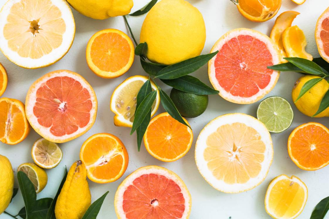 Assorted sliced vitamin c fruits including oranges, grapefruit, lemons, and limes.