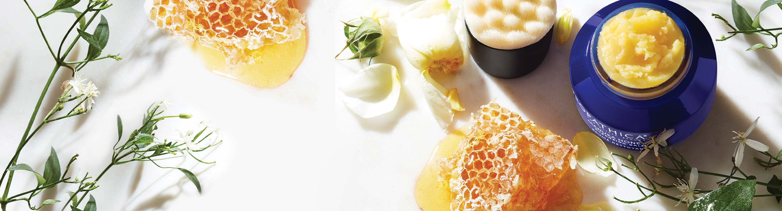 Manuka Honey Cleansing Balm and Brush on table with honey