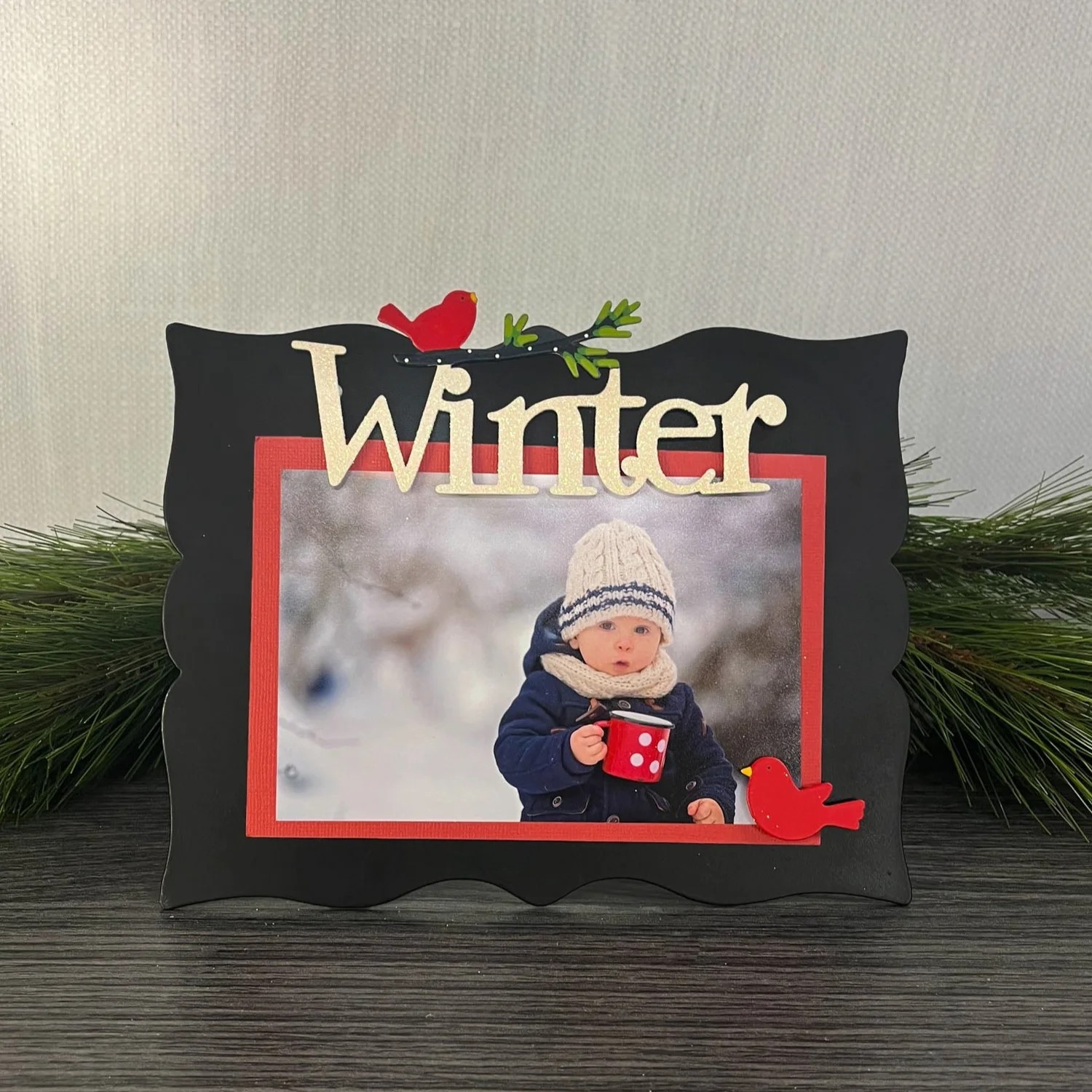 Black easel with "Winter" and red bird magnets and a winter photo. 