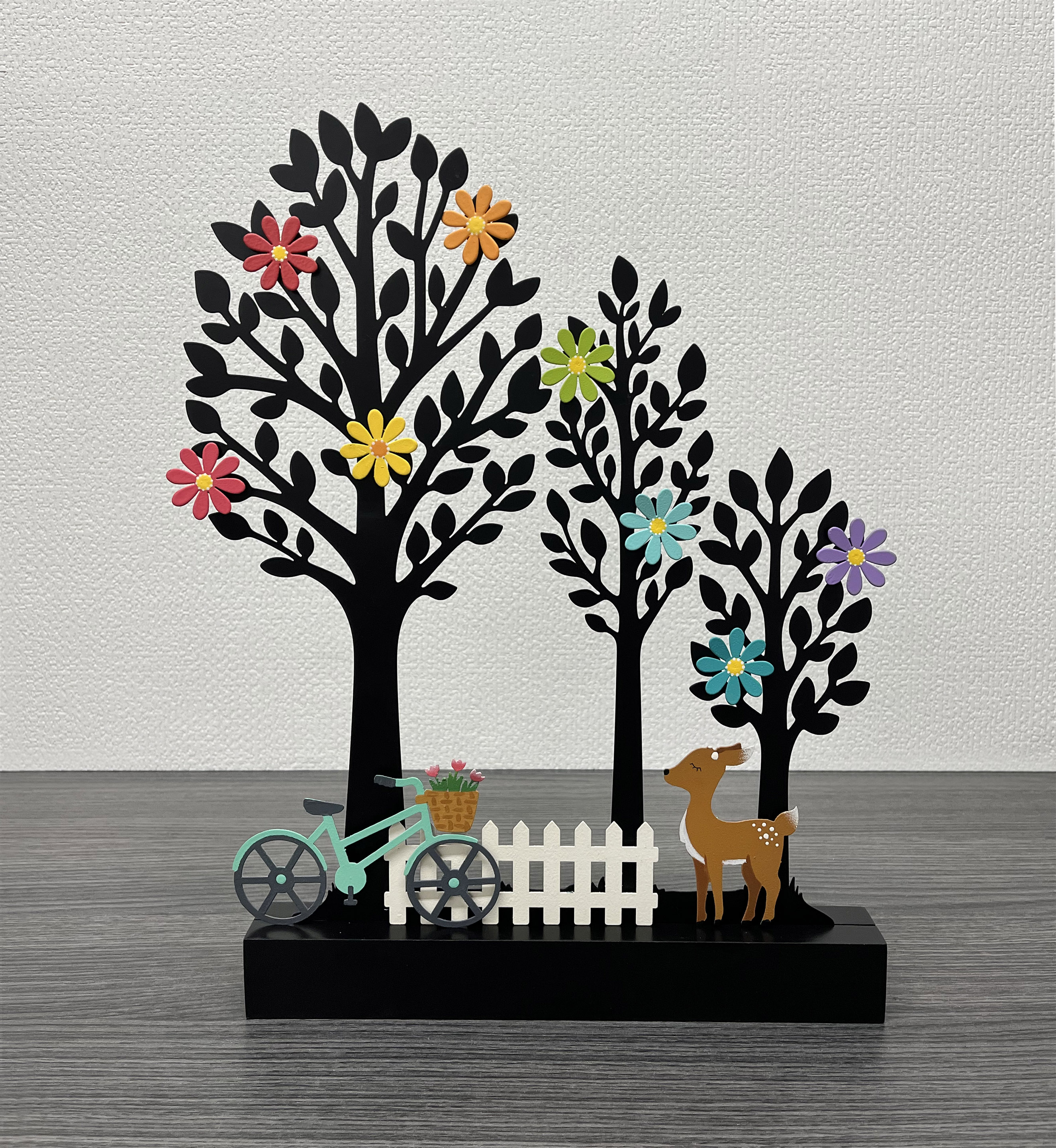 Three black metal tree magnet display with decorative magnets on the trees. 