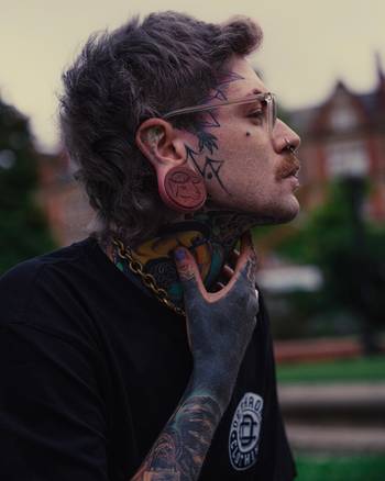 Alternative Tattooed man wearing custom made Sacrificial Lamb Plug / Gauge - Saba Wood | Flat Faced Double Flare