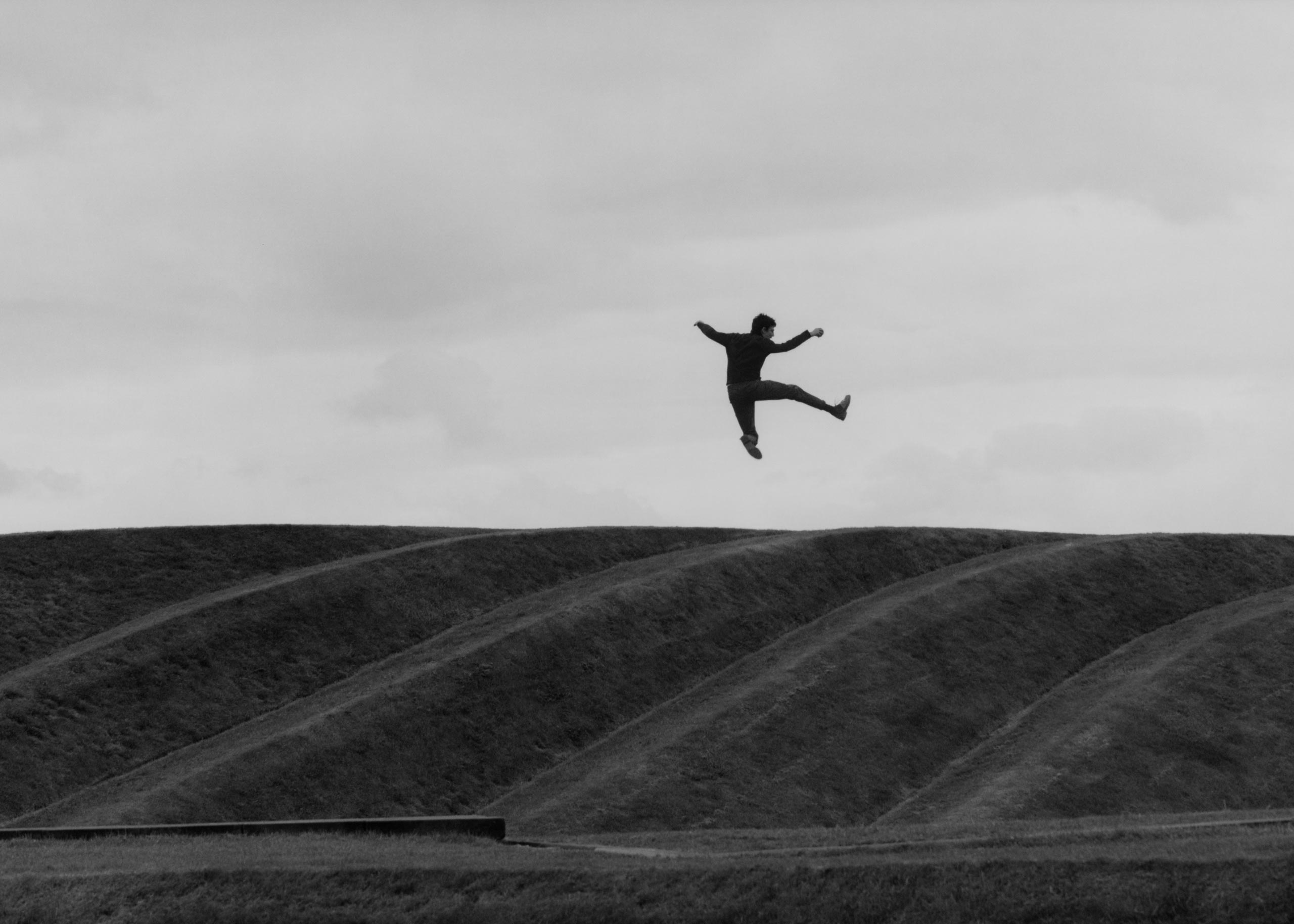 A happy farmer jumping in a field