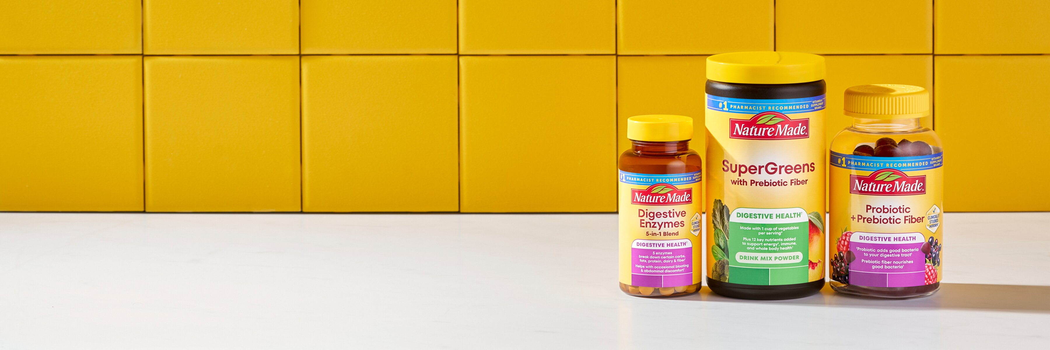 Nature Made digestive health supplements including SuperGreens powder, probiotic+prebiotic fiber gummies, and digestive enzymes on a yellow background