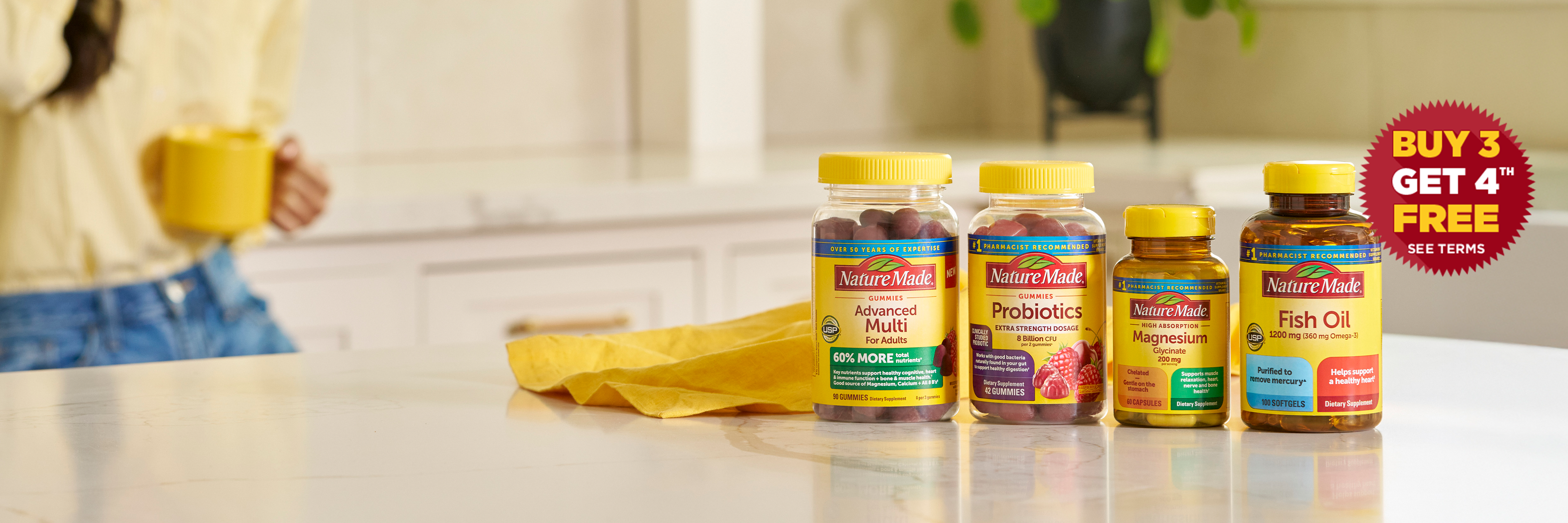 Nature Made vitamins and supplements on a kitchen counter, featuring Advanced Multi, Probiotics, Magnesium, and Fish Oil bottles with a Buy 3 Get 4 Free offer.