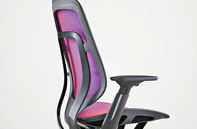 Silla de oficina Steelcase Karman en Shift Red-Blue, de perfil, en una habitación blanca