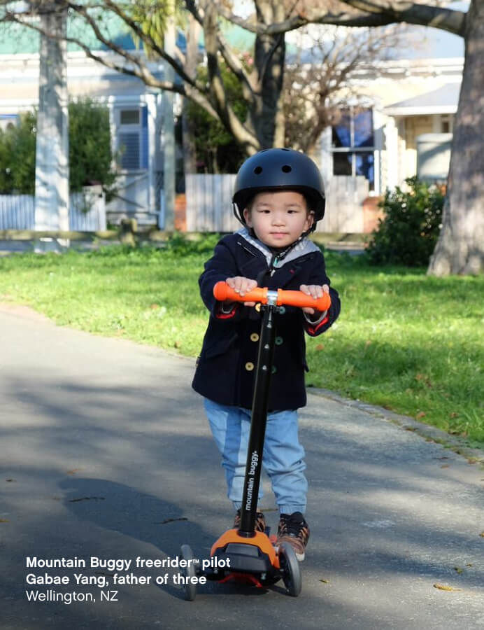 Toddler wearing safety helmet playing on his 3 wheel scooter board - Mountain Buggy freerider™ pilot Gabae Yang, father of four, Hamilton, New Zealand
