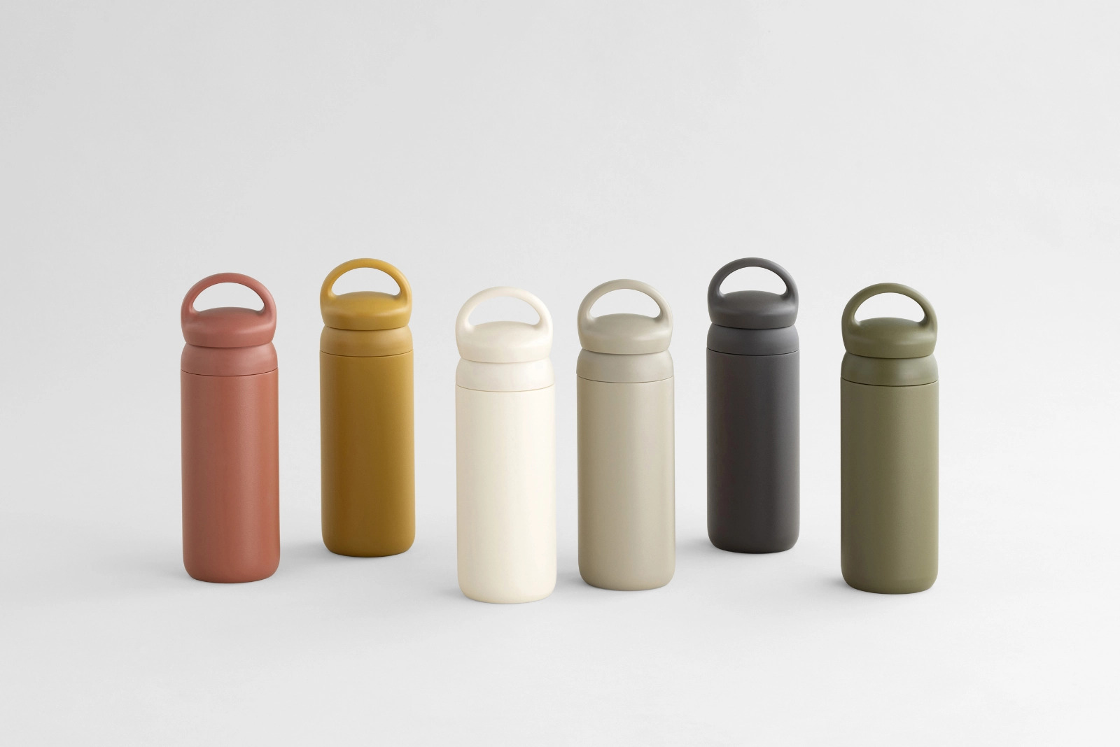  DAY OFF tumblers in green, mustard, orange, and white laid out on a blanket and grass  