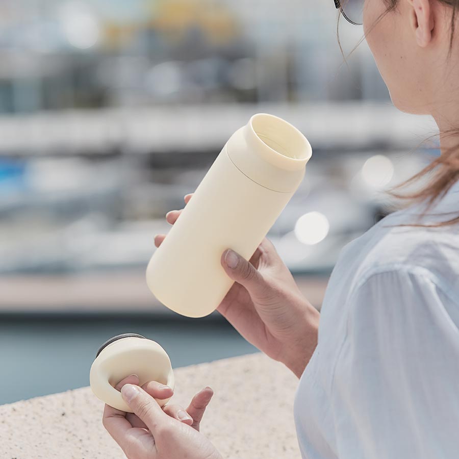  Person about to take a drink out of the DAY OFF tumbler in white  