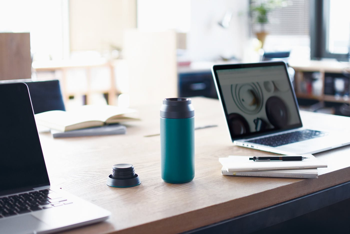  TRAVEL tumbler 500ml in turquoise on a desk with laptops  
