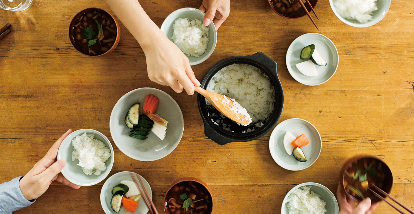  Scooping rice out of the KAKOMI rice cooker with various tableware with food  