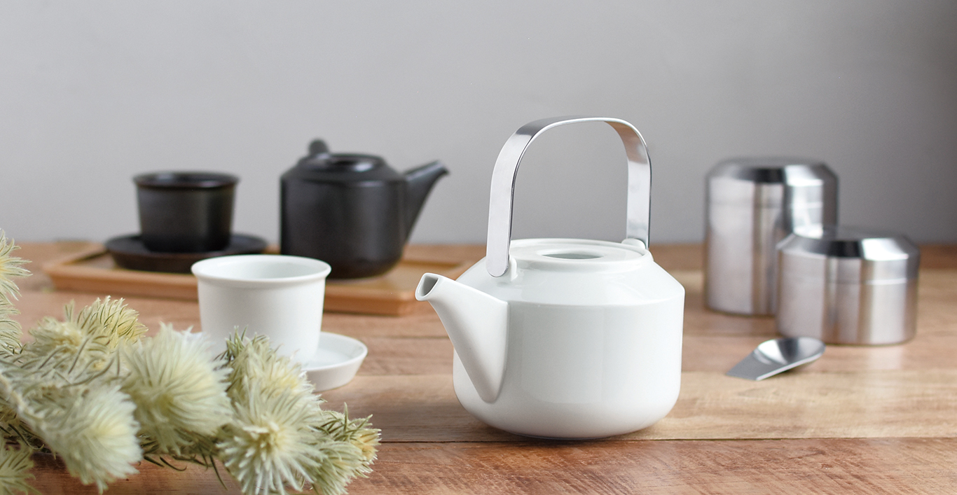  LT teapot in white and cup and saucer. LT kyusu teapot in black with cup and saucer on LT tray. LT tea canister with LT tea scoop 